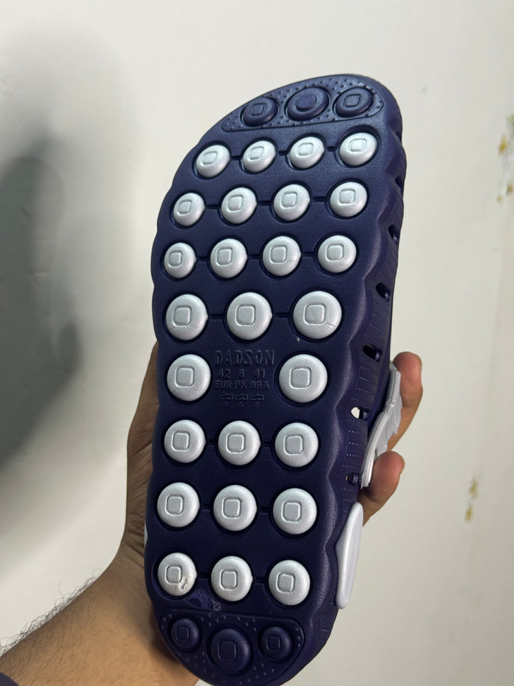 Textured grip outsole of a navy-blue and white clog-style slipper